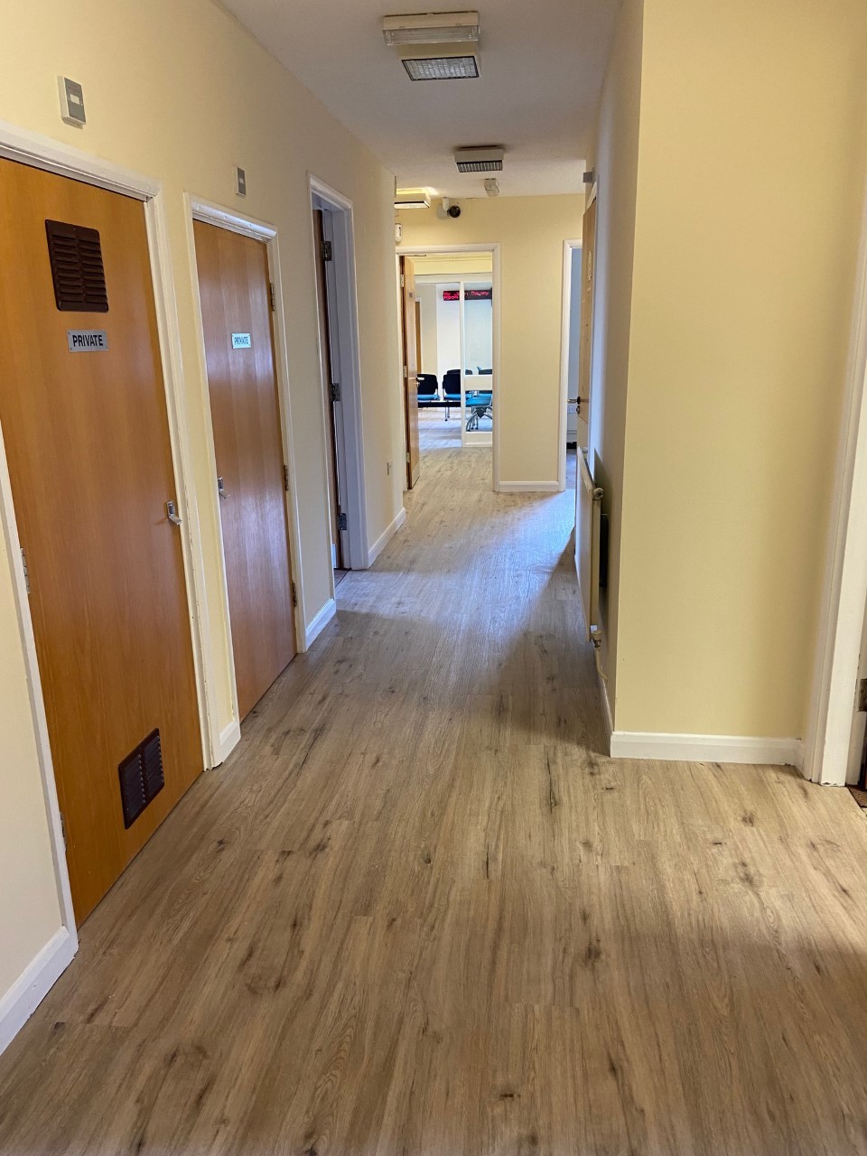 Hallway connecting the waiting rooms at Green Lane Medical Centre, newly painted with new floor, after renovation.